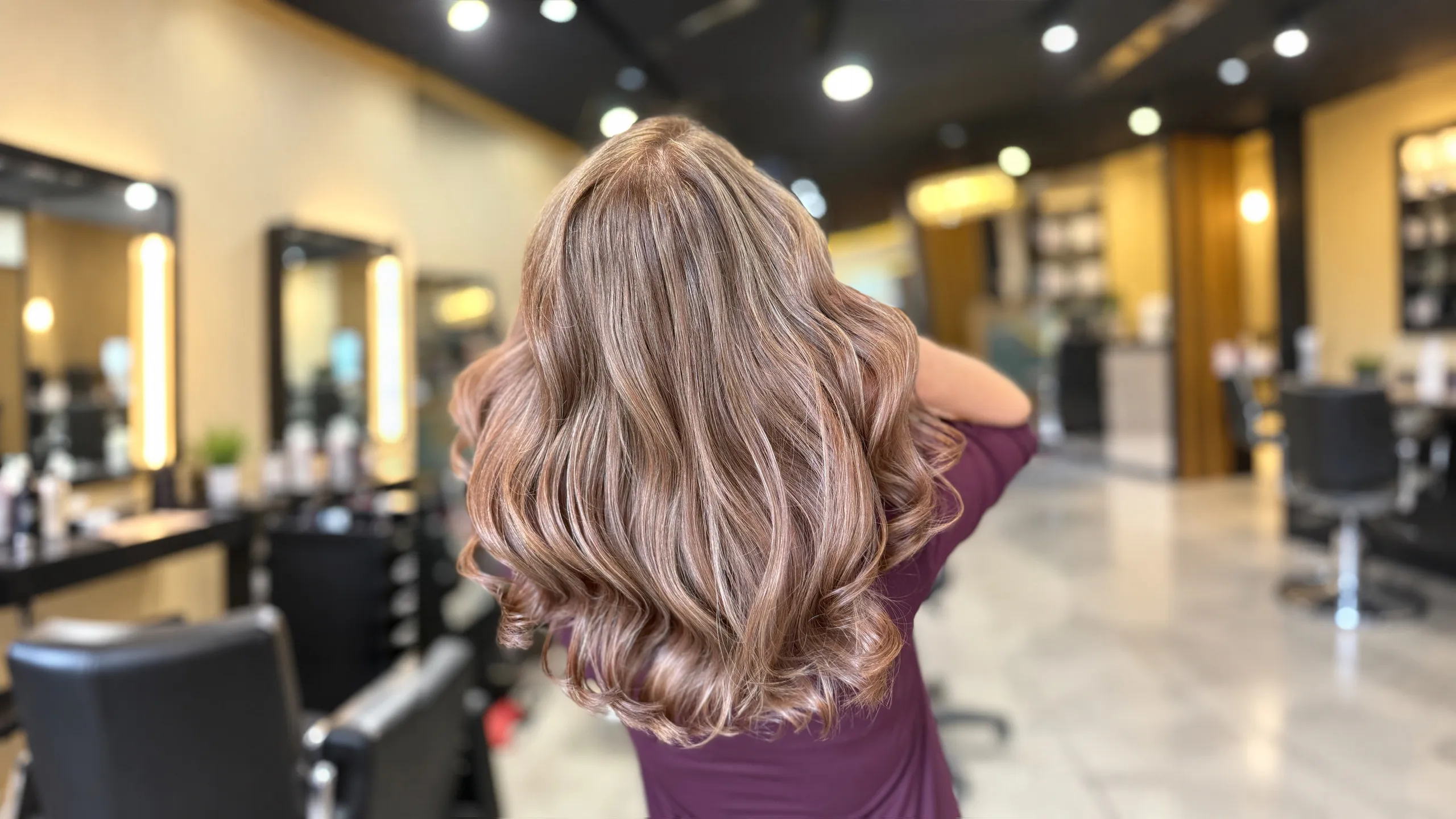 Seidig glänzende Wellen in warmem Rosé-Braun im Salon
